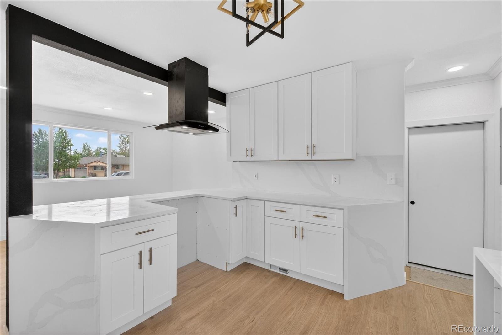 7620 Acoma Court Denver, CO 80221 - Photo 17 of 39 a kitchen with white cabinets and window