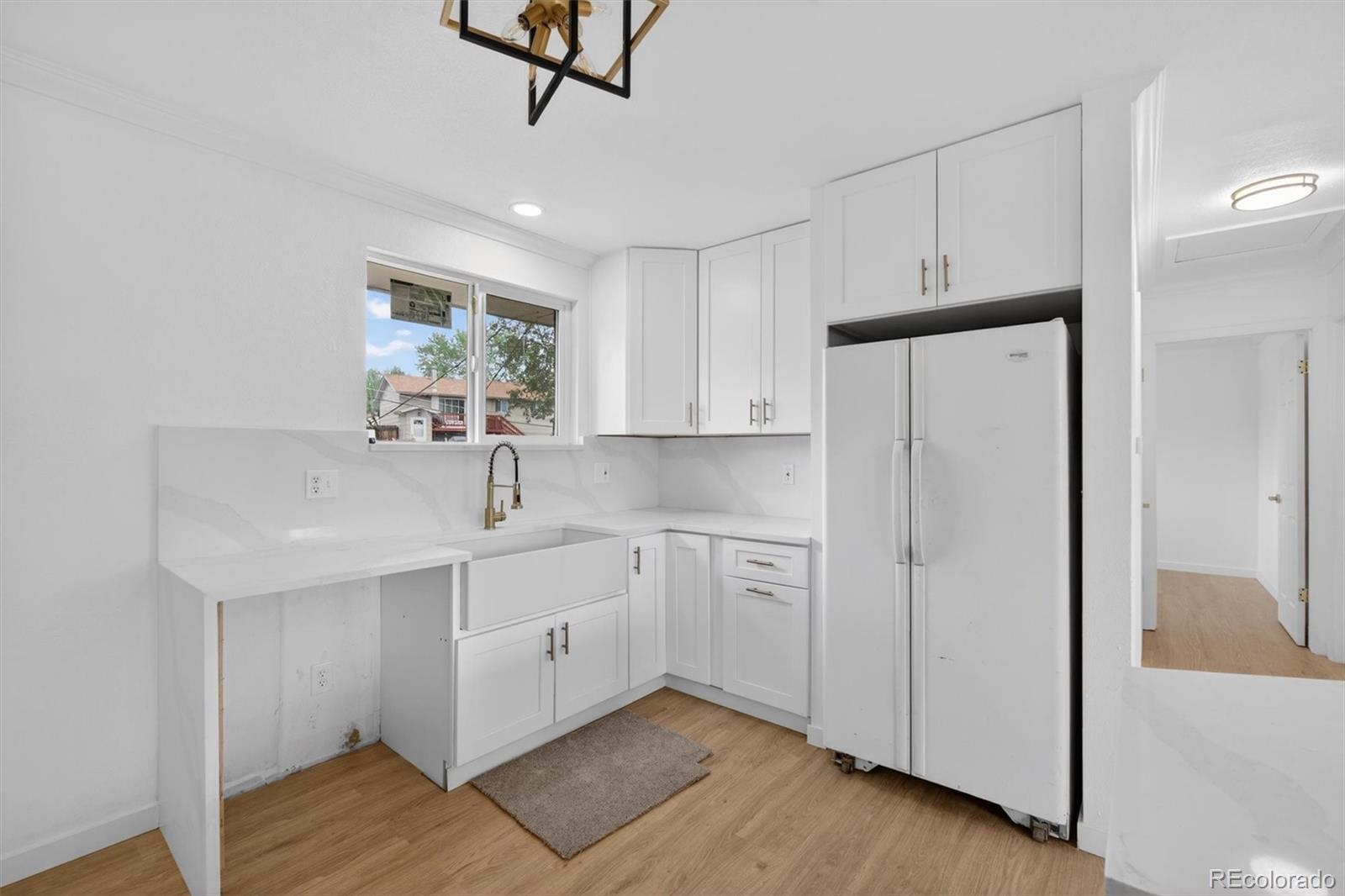 7620 Acoma Court Denver, CO 80221 - Photo 18 of 39 a kitchen with stainless steel appliances a sink cabinets and wooden floor