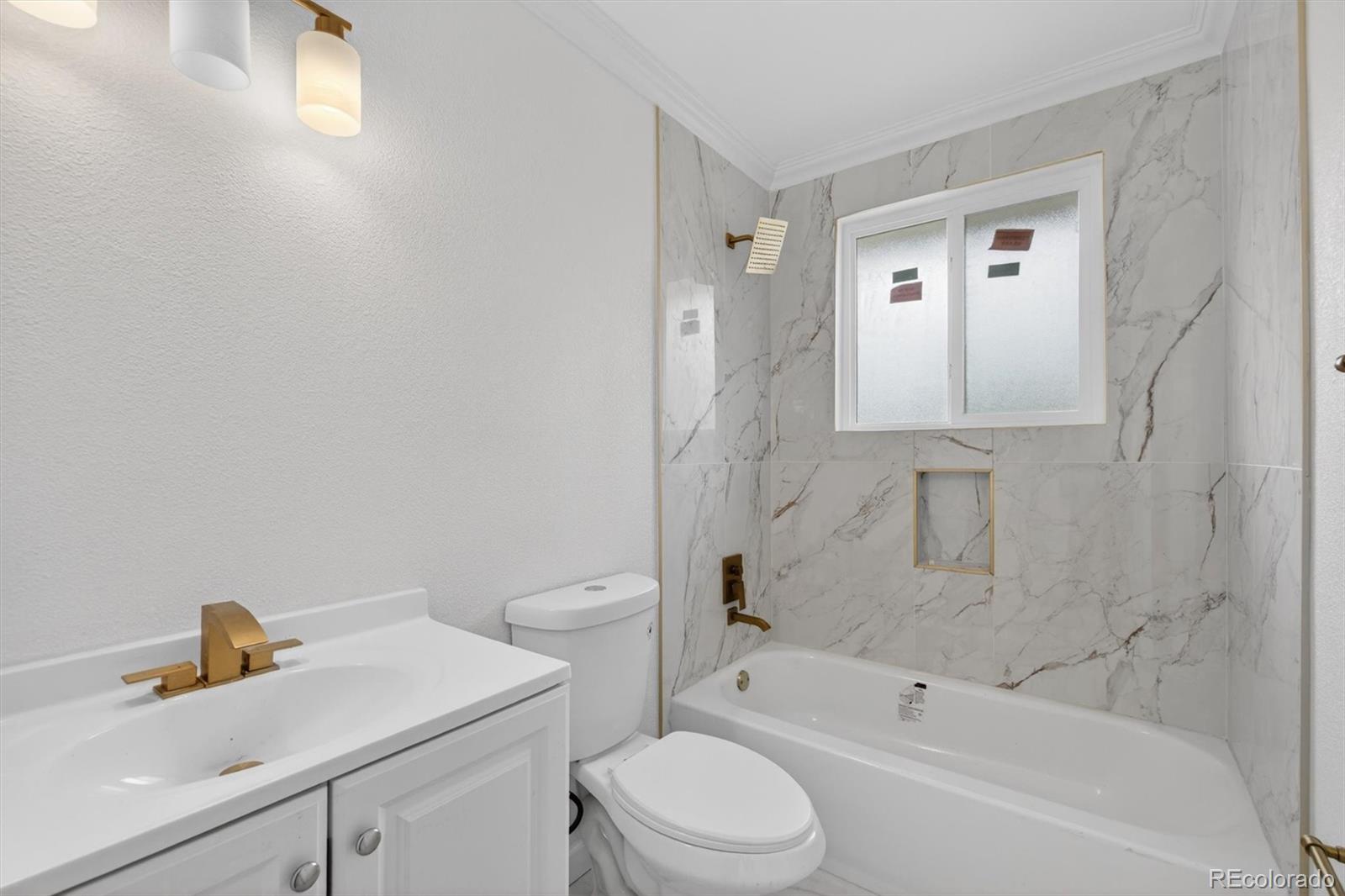 7620 Acoma Court Denver, CO 80221 - Photo 19 of 39 a bathroom with a sink toilet vanity and shower