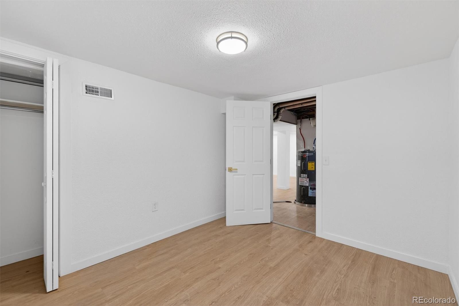 7620 Acoma Court Denver, CO 80221 - Photo 31 of 39 a view of an empty room with wooden floor and a window
