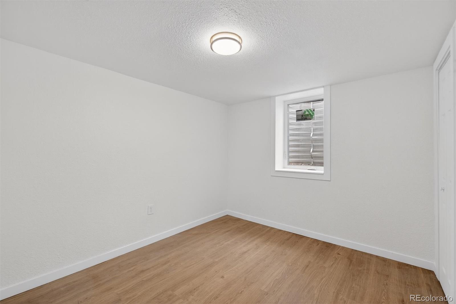 7620 Acoma Court Denver, CO 80221 - Photo 32 of 39 a view of an empty room with wooden floor and a window