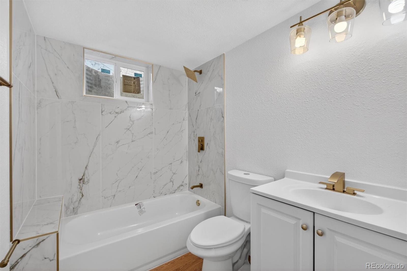 7620 Acoma Court Denver, CO 80221 - Photo 33 of 39 a bathroom with a sink a toilet and shower