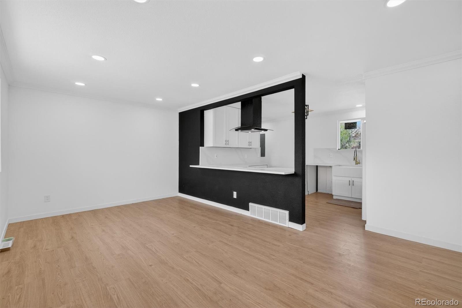 7620 Acoma Court Denver, CO 80221 - Photo 6 of 39 a view of an empty room with wooden floor and a window