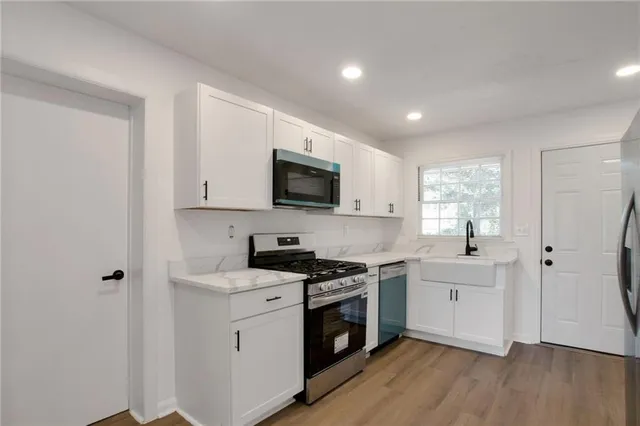a kitchen with a stove a sink and a microwave