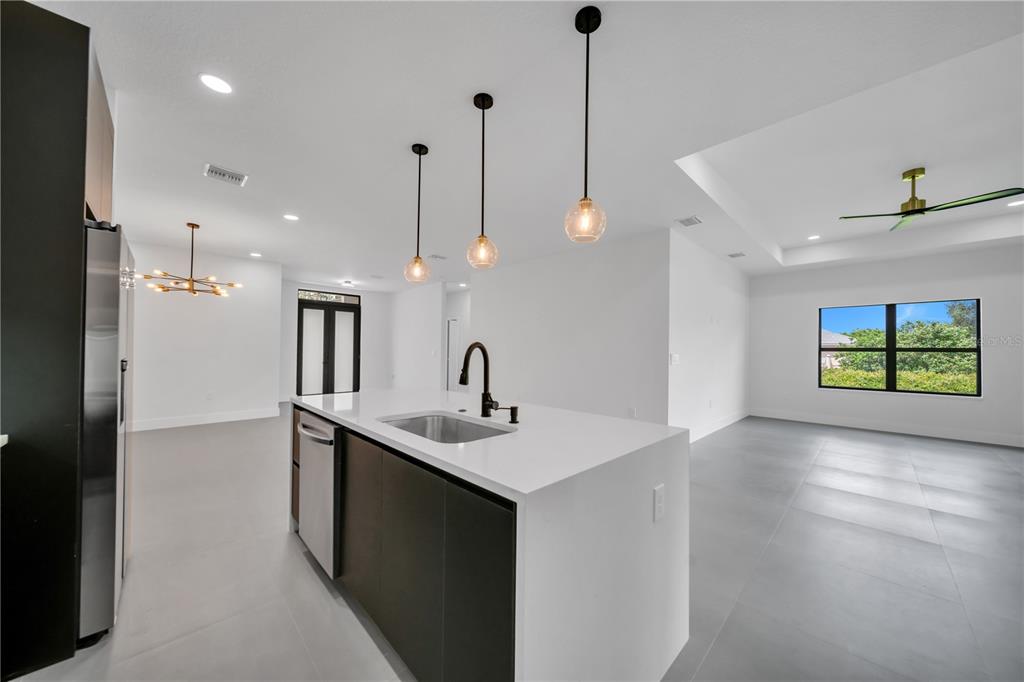 2328 Irondale Road North Port, FL 34287 - Photo 12 of 45 a kitchen with stainless steel appliances granite countertop a sink a window and a wooden floor