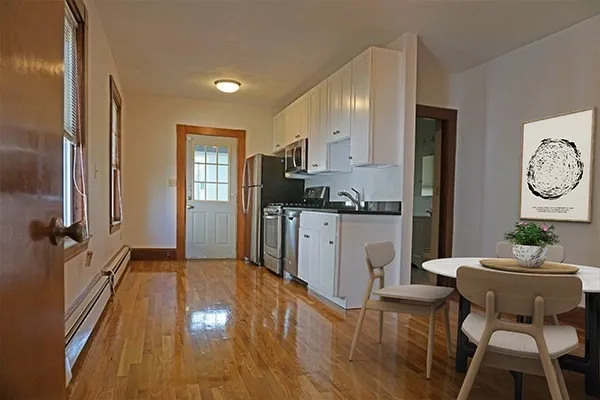 a kitchen with a sink cabinets and wooden floor