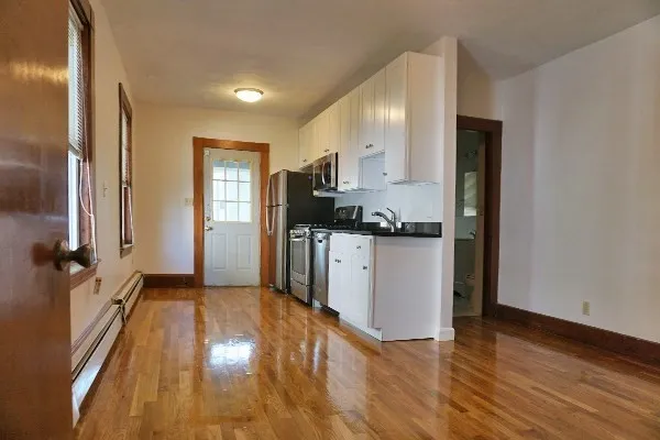 a kitchen with granite countertop a refrigerator and a stove top oven