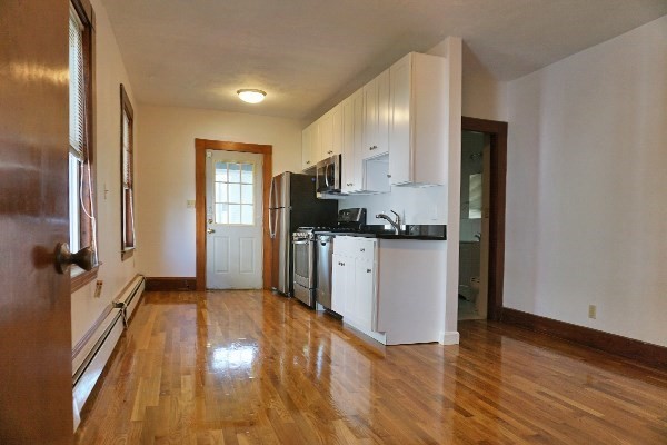 85 Brown Street, Unit 2 Waltham, MA 02453 - Photo 6 of 8 a kitchen with granite countertop a refrigerator and a stove top oven