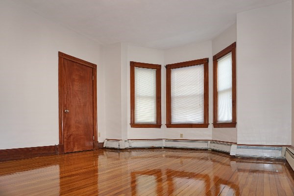 85 Brown Street, Unit 2 Waltham, MA 02453 - Photo 7 of 8 a view of an empty room with a window and wooden floor
