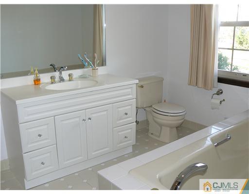 11 Pine Ridge Drive Edison, NJ 08820 - Photo 17 of 25 a bathroom with a toilet a sink a vanity and window