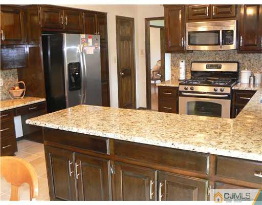 11 Pine Ridge Drive Edison, NJ 08820 - Photo 4 of 25 a kitchen with stainless steel appliances kitchen island granite countertop a refrigerator a stove and a sink