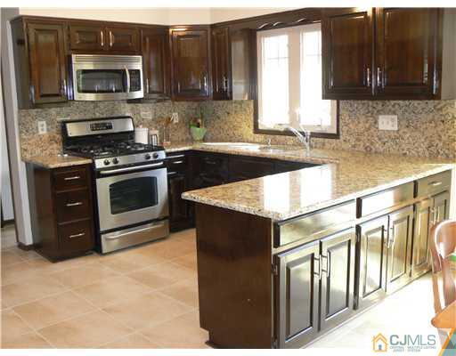 11 Pine Ridge Drive Edison, NJ 08820 - Photo 5 of 25 a kitchen with stainless steel appliances granite countertop a stove a sink and a microwave