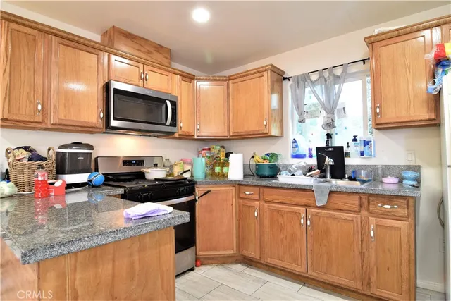 a kitchen with stainless steel appliances kitchen island granite countertop a sink and a microwave