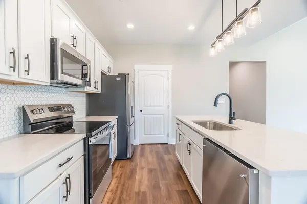 a kitchen with stainless steel appliances granite countertop a sink stove and refrigerator