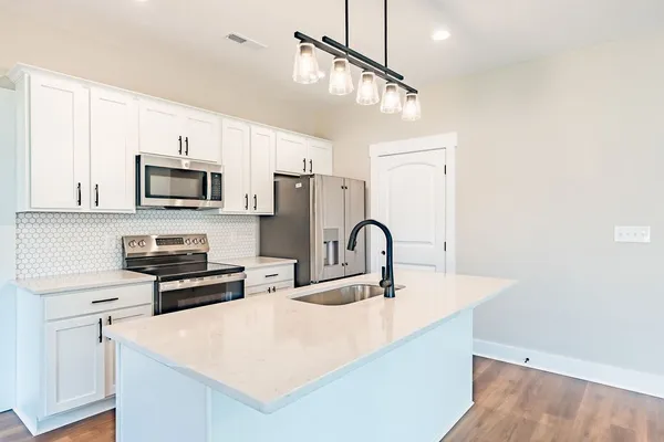 a kitchen with stainless steel appliances a stove microwave and sink