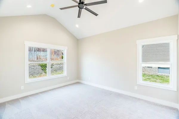 an empty room with a window and a ceiling fan