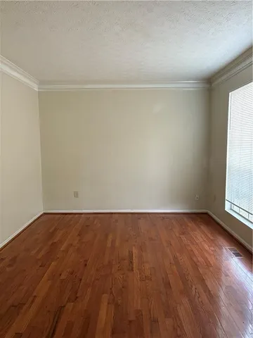 a view of empty room with a fireplace and wooden floor