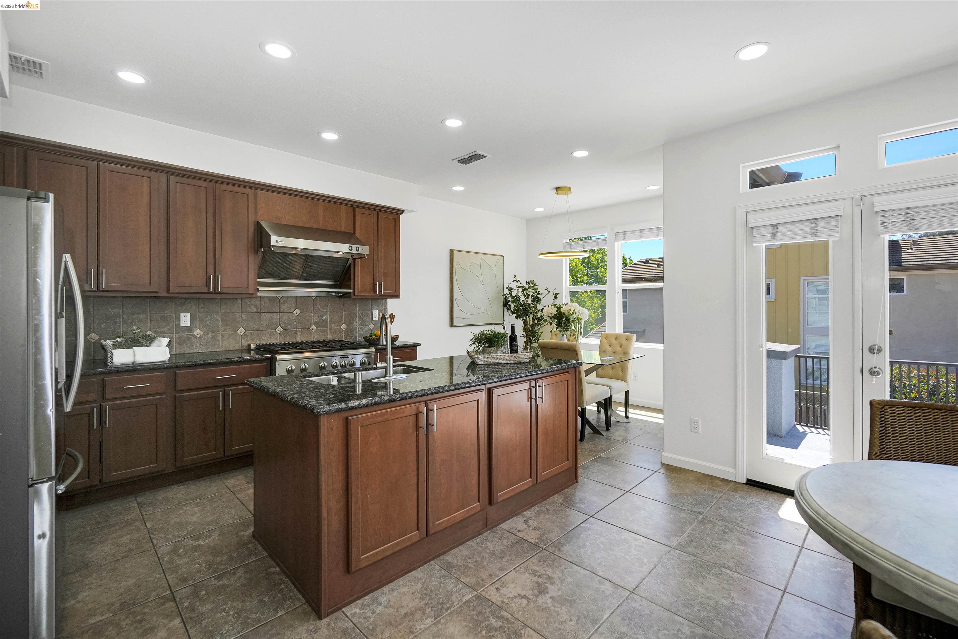 449 Constantine Court San Ramon, CA 94583 - Photo 21 of 63 Kitchen featuring wood cabinetry, granite countertops, tile flooring, and stainless steel appliances including a gas range and refrigerator