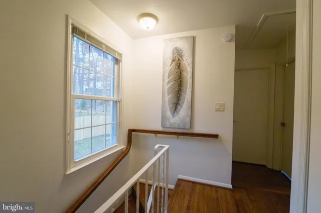 a view of a hallway with wooden floor and entryway