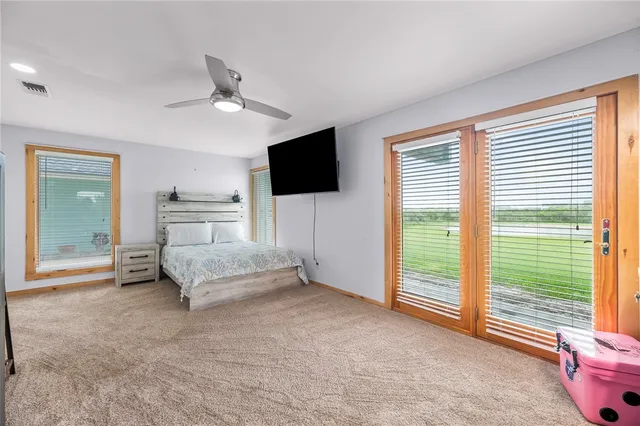 a spacious bedroom with a bed and a television