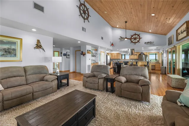 a living room with furniture kitchen view and a chandelier