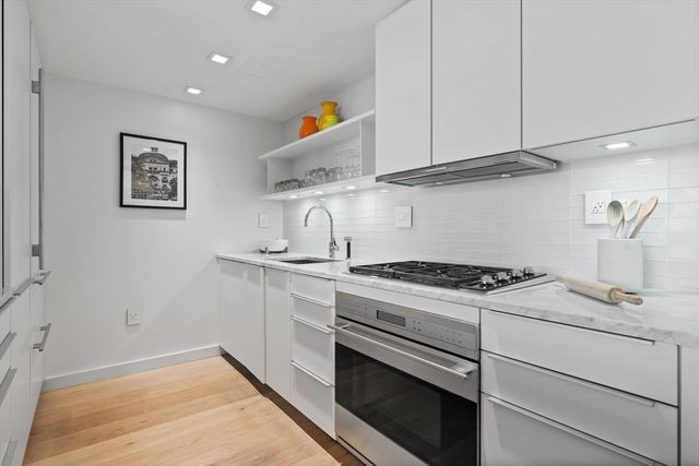 a kitchen with granite countertop cabinets stainless steel appliances and sink
