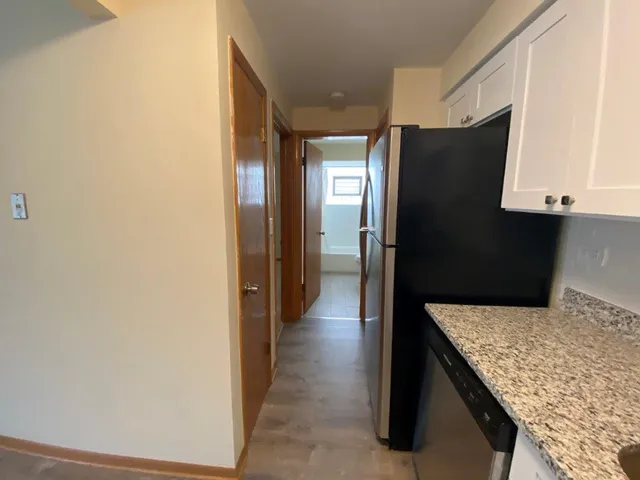 a kitchen with stainless steel appliances granite countertop a refrigerator and a stove top oven