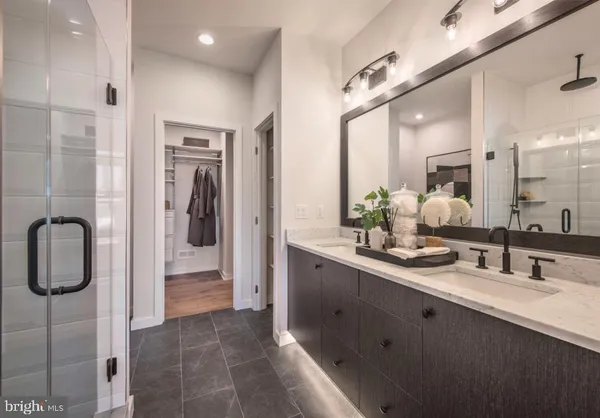 a bathroom with a double vanity sink a mirror and shower