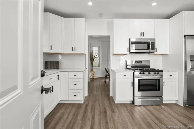 a view of a kitchen with wooden floor and electronic appliances