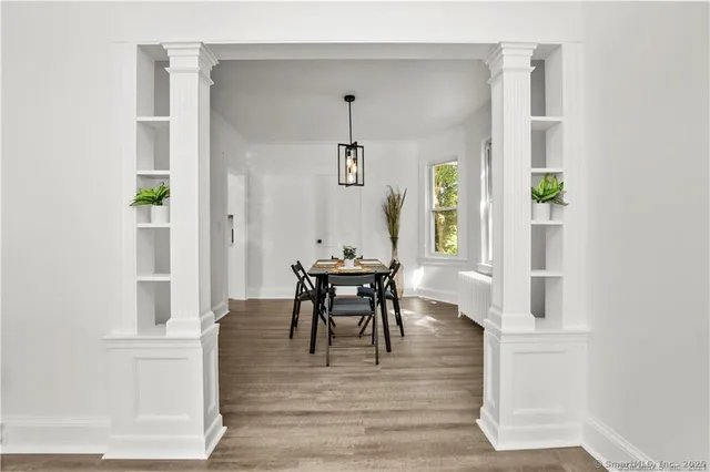 a view of a hallway with wooden floor and furniture