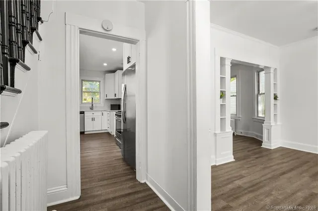 a view of a hallway with wooden floor and staircase