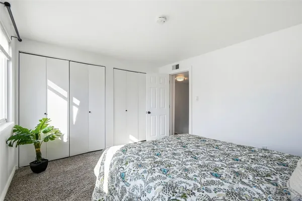 a bedroom with a bed and a potted plant