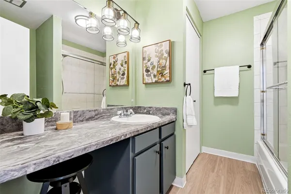 a bathroom with a granite countertop sink a large mirror and a shower