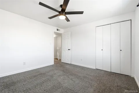 an empty room with a ceiling fan and a window