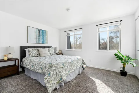 a bedroom with a bed lamp and a potted plant