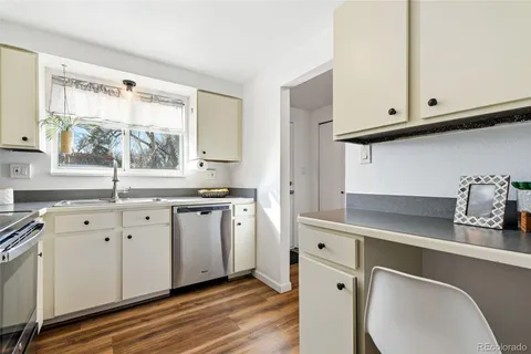 a kitchen with white cabinets and window