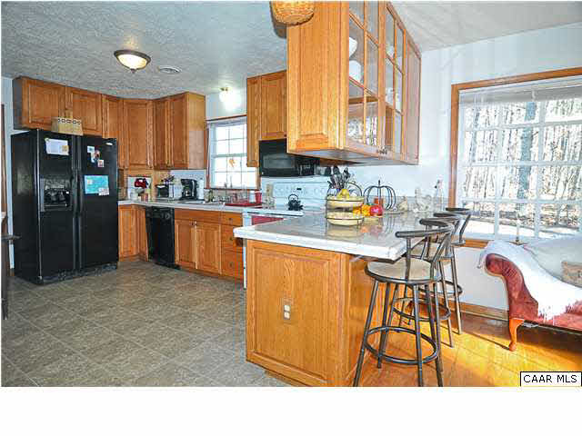 9057 Poindexter Road Louisa, VA 23093 - Photo 8 of 35 a kitchen with stainless steel appliances granite countertop a refrigerator a sink a stove and cabinets