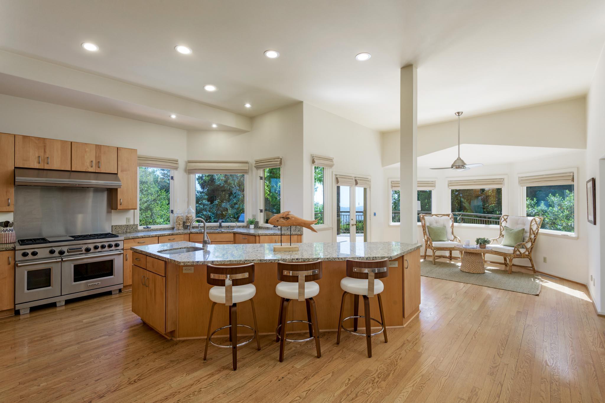 1235 Mission Ridge Road Santa Barbara, CA 93103 - Photo 7 of 27 a kitchen with kitchen island granite countertop wooden floors and stainless steel appliances