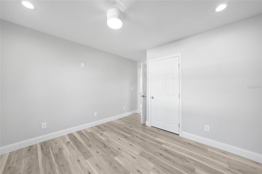 1450 New Point Comfort Road Englewood, FL 34223 - Photo 13 of 50 an empty room with wooden floor and windows