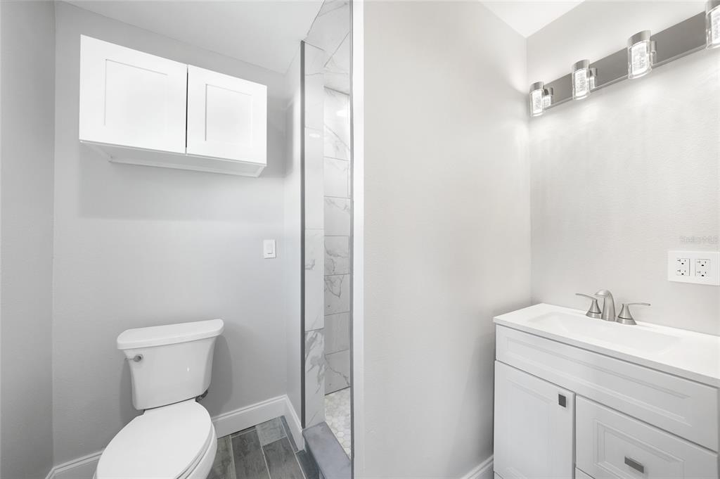 1450 New Point Comfort Road Englewood, FL 34223 - Photo 17 of 50 a bathroom with a toilet sink and mirror