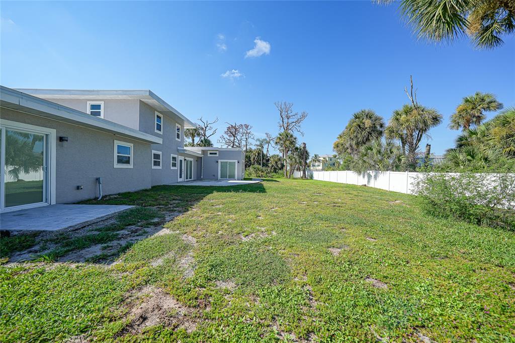1450 New Point Comfort Road Englewood, FL 34223 - Photo 36 of 50 a backyard of a house with plants and large tree