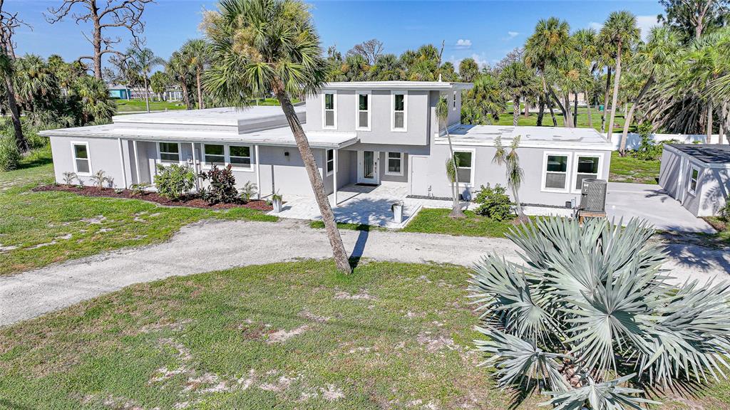 1450 New Point Comfort Road Englewood, FL 34223 - Photo 43 of 50 a front view of a house with a yard table and chairs