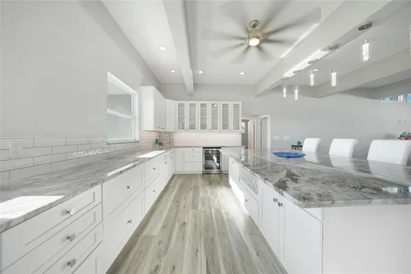 a large kitchen with kitchen island a large counter space a sink appliances and cabinets