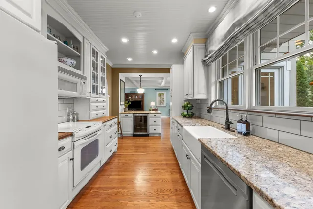 a large kitchen with stainless steel appliances granite countertop lots of counter top space and wooden floor