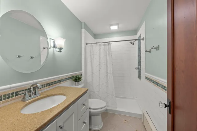 a bathroom with a granite countertop sink toilet and shower