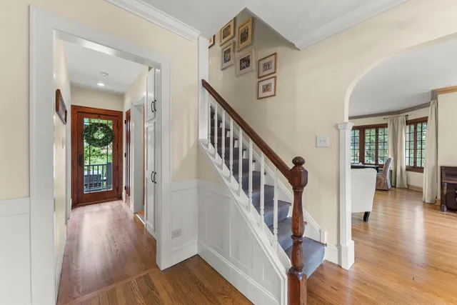 a view of a hallway with wooden floor and stairs