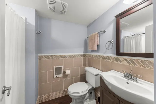 a bathroom with a sink a toilet and mirror