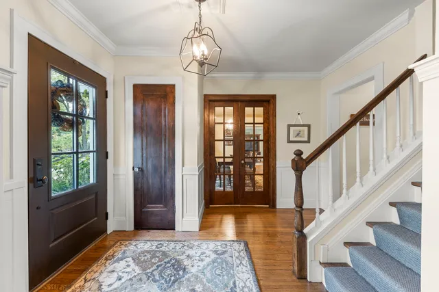a view of a hallway with wooden floor and windows