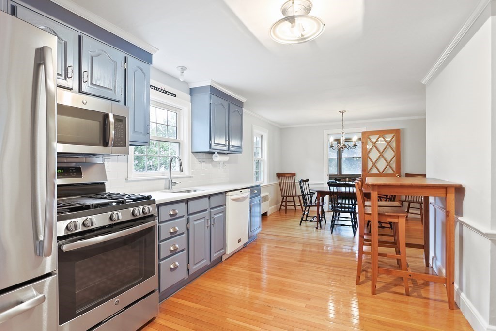 3 Overlook Road Needham, MA 02492 - Photo 6 of 32 a kitchen with stainless steel appliances granite countertop a stove top oven a sink a dining table and chairs with wooden floor