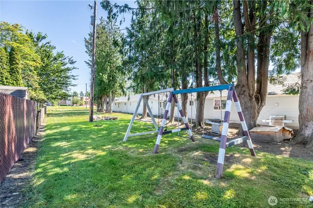 a view of a backyard with table and chairs and a large tree